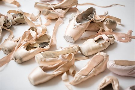simsearch:400-09029135,k - Many pairs of ballet shoes lie in a chaotic order on the floor. Pointe in a different state from new to severely trampled. Horizontal. Stock Photo - Budget Royalty-Free & Subscription, Code: 400-09029134