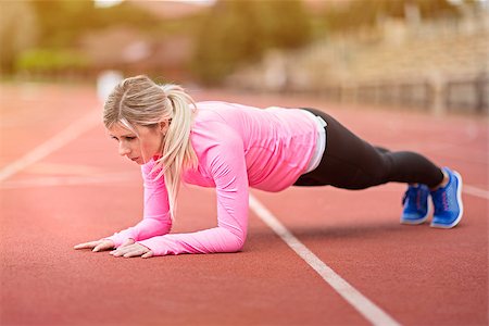 faire - side view of young slim attractive woman doing plank exercise at outdoor stadium, core training and fitness concept, sun flare Photographie de stock - Aubaine LD & Abonnement, Code: 400-09029436