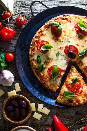 simsearch:400-04539943,k - Pizza on wood with ingredients. Pizza with cheese, tomatoes and basil. Rustic italian pizza Stockbilder - Microstock & Abonnement, Bildnummer: 400-09029625