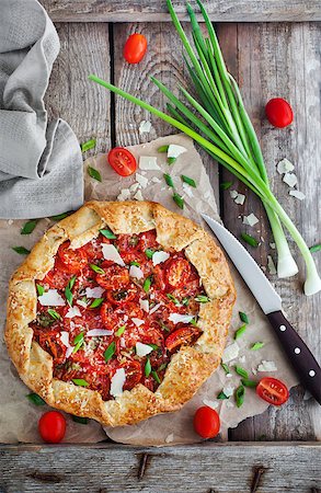 simsearch:400-04376706,k - Delicious homemade rustic open pie (galette) with tomato, cheese and onion, wooden background Stock Photo - Budget Royalty-Free & Subscription, Code: 400-09030210