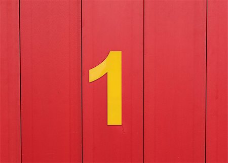 the number one, yellow, set against bright red wood Stockbilder - Microstock & Abonnement, Bildnummer: 400-09045617