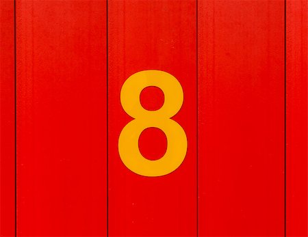 the number eight, yellow, set against bright red wood Stockbilder - Microstock & Abonnement, Bildnummer: 400-09045625
