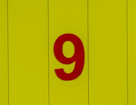 the number nine, red, set against bright yellow wood Stockbilder - Microstock & Abonnement, Bildnummer: 400-09045626