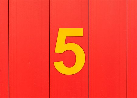 the number five, yellow, set against bright red wood Stockbilder - Microstock & Abonnement, Bildnummer: 400-09045622