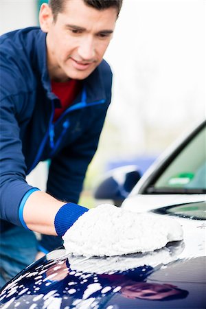 Hard-working young man polishing car with white microfiber mitt at auto wash Stock Photo - Budget Royalty-Free & Subscription, Code: 400-09064290