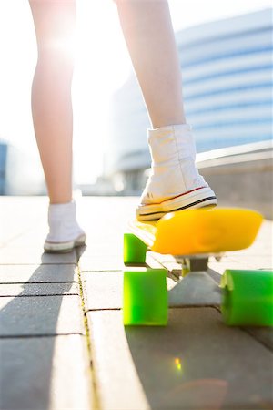 Close up of sport woman in white sneakers ready to extreme funny ride her penny board skateboard in sun light. Modern urban hipster girl have fun. Good sunny summer day for skateboarding and have fun. Stock Photo - Budget Royalty-Free & Subscription, Code: 400-09064522