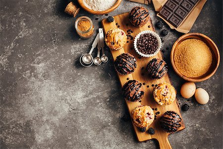 Different homemade muffins with chocolate and berries and baking ingredients. Food background wiht copyspace. Stock Photo - Budget Royalty-Free & Subscription, Code: 400-09067225