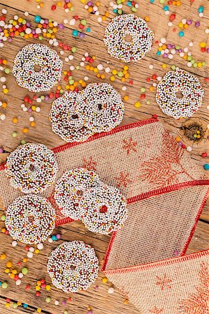 Colored chocolate rings with Christmas decoration on wood table Foto de stock - Super Valor sin royalties y Suscripción, Código: 400-09068508
