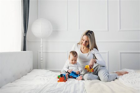 simsearch:400-08787277,k - Happy mother with her cute little child on the bed having a good time Stock Photo - Budget Royalty-Free & Subscription, Code: 400-09062775