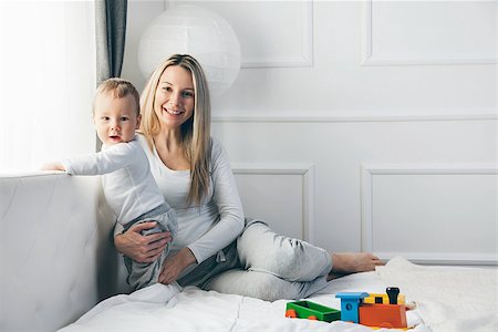 simsearch:400-08787277,k - Happy mother with her cute little child on the bed having a good time Stock Photo - Budget Royalty-Free & Subscription, Code: 400-09062776