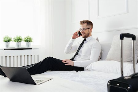 simsearch:400-05209351,k - Young businessman working from a hotel room with his mobile phone Stock Photo - Budget Royalty-Free & Subscription, Code: 400-09062854