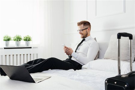 simsearch:400-05209351,k - Young businessman working from a hotel room with his mobile phone Stock Photo - Budget Royalty-Free & Subscription, Code: 400-09062855