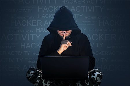 simsearch:649-08765870,k - Man with hidden face working at a computer. Holding a finger to his mouth. Computer hacker stealing data from a laptop concept for network security, identity theft and computer crime Fotografie stock - Microstock e Abbonamento, Codice: 400-09063107
