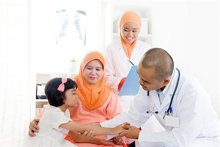 Southeast Asian child patient consulting medical doctor. Muslim family. Little girl with broken arm doing health check. Stock Photo - Budget Royalty-Free & Subscription, Code: 400-09063526