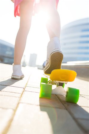 Close up of slim lady in white sneakers ready to extreme funny ride her penny board skateboard in sun light. Modern urban hipster girl have fun. Good sunny summer day for skateboarding and have fun. Stock Photo - Budget Royalty-Free & Subscription, Code: 400-09063703