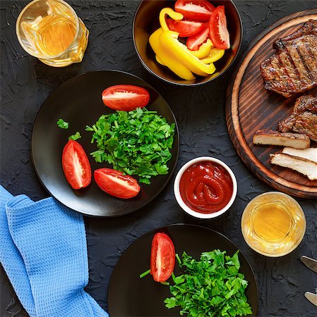 frying chicken in pan - Tasty and juicy steaks, various fresh vegetables, greens, wine and beer on a black stone background. Concept: dinner in a restaurant Stock Photo - Budget Royalty-Free & Subscription, Code: 400-09070012