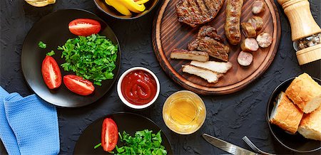 frying chicken in pan - Tasty and juicy steaks, various fresh vegetables, greens, wine and beer on a black stone background. Concept: dinner in a restaurant Stock Photo - Budget Royalty-Free & Subscription, Code: 400-09070013