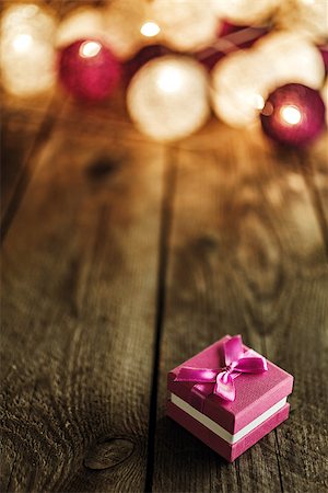 Christmas background with decorations and purple gift box on wooden board. Soft lights in the background. Stock Photo - Budget Royalty-Free & Subscription, Code: 400-09084201