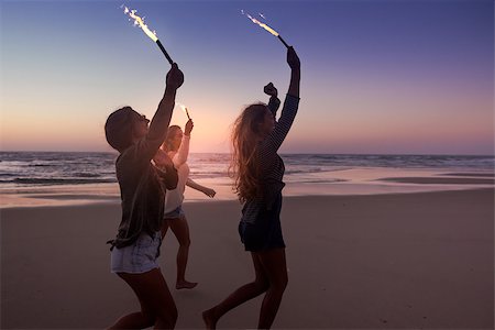 sunset hang out - Teenage friends running on a beach with fireworks Foto de stock - Super Valor sin royalties y Suscripción, Código: 400-09081966