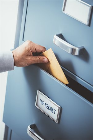 supersecretos - Businessman putting an envelope into a top secret classified drawer, data protection and storage concept Foto de stock - Super Valor sin royalties y Suscripción, Código: 400-09082230