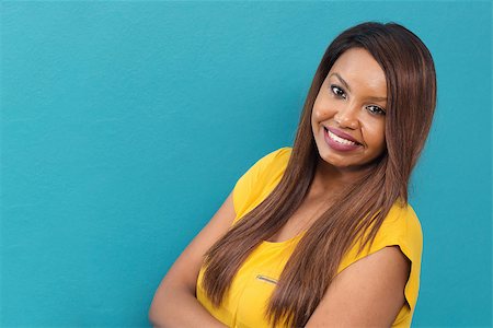 Girl Looking at the Camera and Smiling on Cyan Background Stock Photo - Budget Royalty-Free & Subscription, Code: 400-09082506