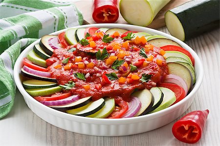 Raw ingredients zucchini, bell pepper, onion, eggplant, tomato sauce and parsley in gratin dish for traditional French ratatouille Fotografie stock - Microstock e Abbonamento, Codice: 400-09082686