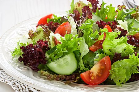 simsearch:400-07894253,k - Fresh salad with green, red lettuce, tomato and cucumber Photographie de stock - Aubaine LD & Abonnement, Code: 400-09082692