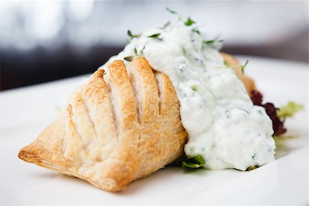 simsearch:400-08427153,k - Traditional russian pie - coulibiac. Baked puff pastry filled with smoked salmon, served with sour cream sauce Stock Photo - Budget Royalty-Free & Subscription, Code: 400-09083040