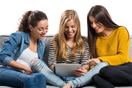 Girls sitting in the couch watching something on a tablet Stock Photo - Budget Royalty-Free & Subscription, Code: 400-09083264