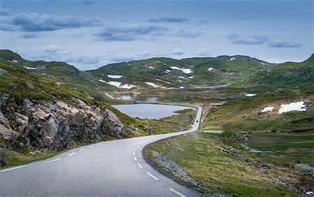 steffus (artist) - Scenic mountain road through the rocks and lakes with some snow on the green hills. Norway summer. Fotografie stock - Microstock e Abbonamento, Codice: 400-09094852