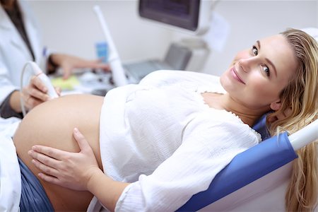 simsearch:6109-08434625,k - Happy pregnant female visiting women's doctor in the maternity center, with pleasure doing ultrasound scan, checking health of the child, healthy motherhood concept Stock Photo - Budget Royalty-Free & Subscription, Code: 400-09095799
