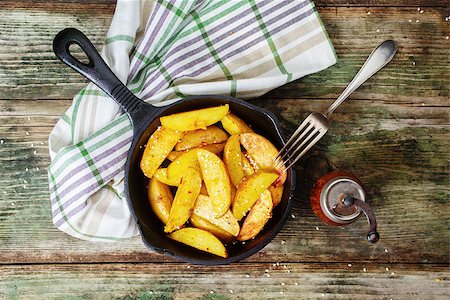 simsearch:400-05751294,k - Potatoes cooked in a cast iron skillet on a rustic wooden background Foto de stock - Super Valor sin royalties y Suscripción, Código: 400-09096482