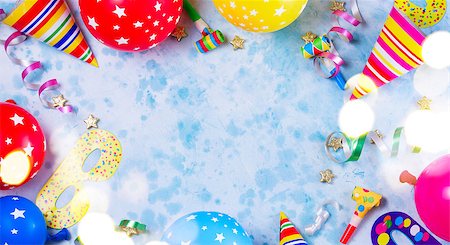 Bright colorful carnival or party scene frame of balloons, streamers and confetti on blue table. Flat lay style, birthday or party greeting card with copy space and bokeh lights Stock Photo - Budget Royalty-Free & Subscription, Code: 400-09096735