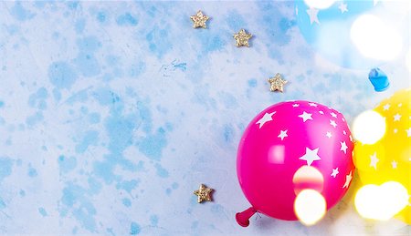 simsearch:400-05693376,k - Bright colorful carnival or party scene of balloons on blue table. Flat lay style, birthday or party greeting card with copy space and bokeh lights Stockbilder - Microstock & Abonnement, Bildnummer: 400-09096733