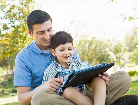 family with tablet in the park - Happy Father and Son Playing on a Computer Tablet Outside. Stock Photo - Budget Royalty-Free & Subscription, Code: 400-09096933