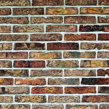 Background of Multi Colored Old Brick Wall with Cracked Surface and Concrete closeup Outdoors Stock Photo - Budget Royalty-Free & Subscription, Code: 400-09097234