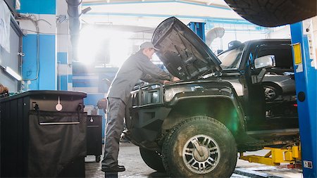 Mechanic male in automobile garage checking hood of the car for luxury SUV, horizontal, wide angle Stock Photo - Budget Royalty-Free & Subscription, Code: 400-09091313