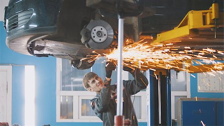 steel plant weld - Car auto service - worker grinding metal construction with a circular saw under bottom of the vehicle, telephoto Stock Photo - Budget Royalty-Free & Subscription, Code: 400-09092046