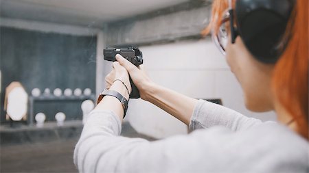 simsearch:400-05686969,k - Woman shooting with a gun in shooting gallery, close up Foto de stock - Super Valor sin royalties y Suscripción, Código: 400-09092881