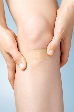 simsearch:400-07824013,k - Woman putting an adhesive bandage on her leg Foto de stock - Royalty-Free Super Valor e Assinatura, Número: 400-09119784