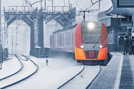 simsearch:400-07680071,k - Highspeed train approaches to the station platform at snowstormy day time. Photographie de stock - Aubaine LD & Abonnement, Code: 400-09112595
