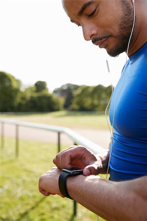 Male athlete at running track setting smartwatch app Stock Photo - Budget Royalty-Free & Subscription, Code: 400-09121808