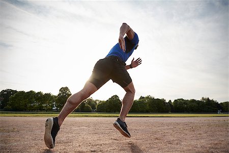 simsearch:632-06118219,k - Young male athlete running at a track, low angle view Stock Photo - Budget Royalty-Free & Subscription, Code: 400-09121814