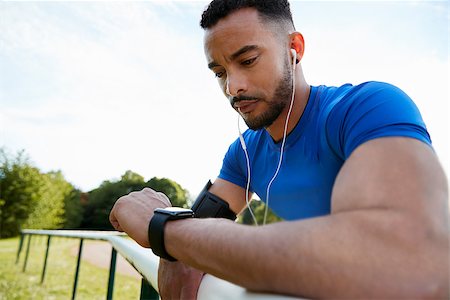 Male athlete at track checking smartwatch app, close up Stock Photo - Budget Royalty-Free & Subscription, Code: 400-09121810