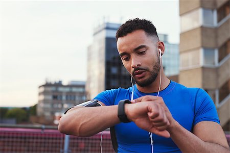 Male runner uses app on smartwatch in urban street, close up Stock Photo - Budget Royalty-Free & Subscription, Code: 400-09121827