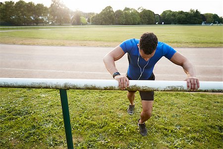 simsearch:632-06118219,k - Male athlete stretching at running track, close up Stock Photo - Budget Royalty-Free & Subscription, Code: 400-09121820