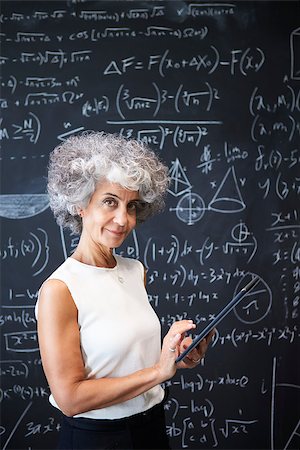 Middle aged academic woman at blackboard smiling to camera Stock Photo - Budget Royalty-Free & Subscription, Code: 400-09121927