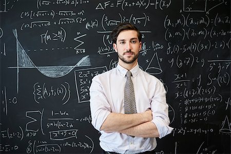 simsearch:695-03378508,k - Young man looking to camera in front of a blackboard Stock Photo - Budget Royalty-Free & Subscription, Code: 400-09121920