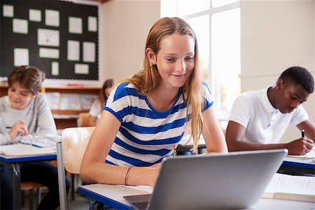 simsearch:400-09121991,k - Female Pupil Sitting At Desk In Class Room Using Laptop Fotografie stock - Microstock e Abbonamento, Codice: 400-09122032