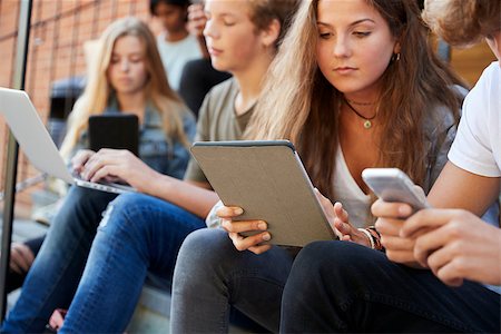 student group outside with laptop - Teenage Students Using Digital Devices On College Campus Foto de stock - Super Valor sin royalties y Suscripción, Código: 400-09122041